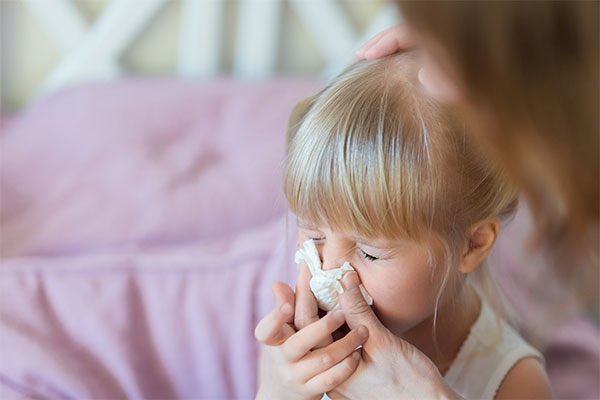 Mother Helping Sick Child Blow Nose